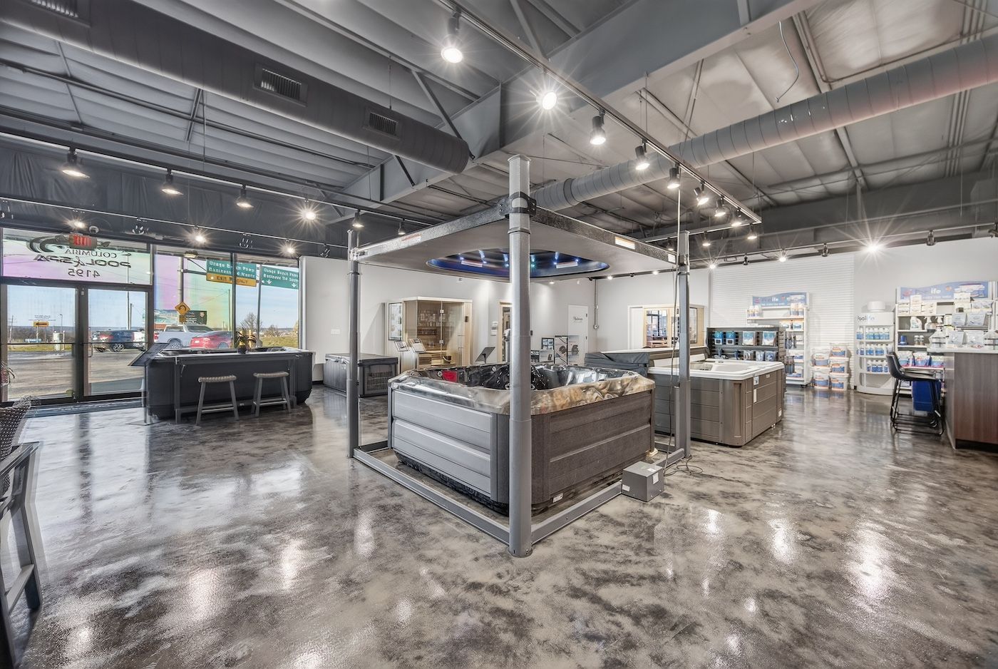 Bright modern store interior with polished concrete floors, shelving, and display counters under exposed ceilings