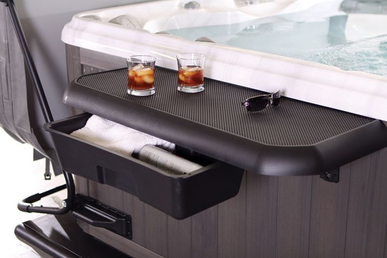 Hot tub side tray with two drinks and sunglasses on a dark textured surface