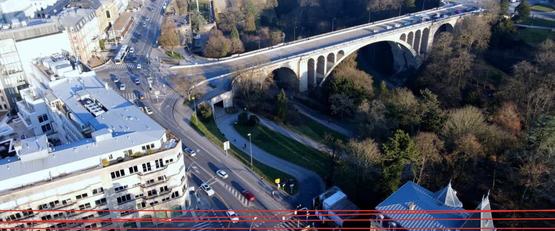 Due persone in abiti da lavoro sistemano grosse pile di documenti cartacei su una scrivania.