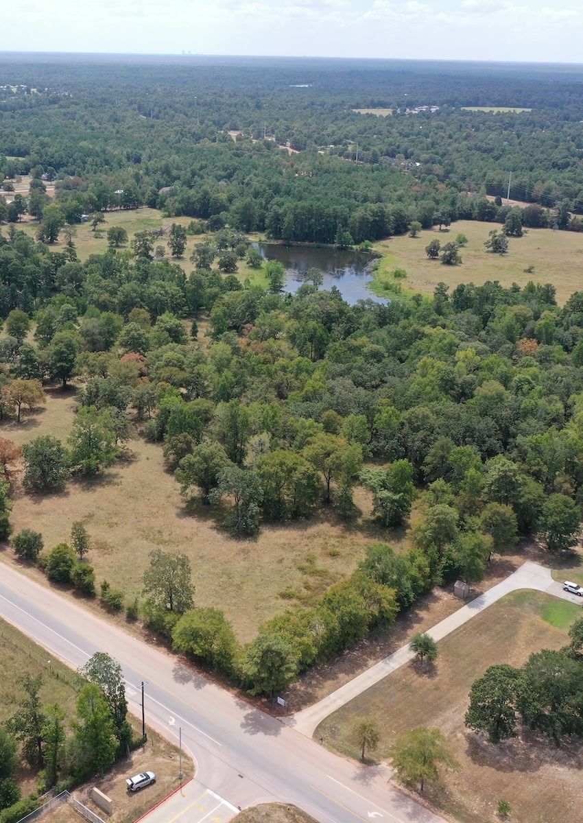An aerial view of a lush green forest with a lake in the middle.