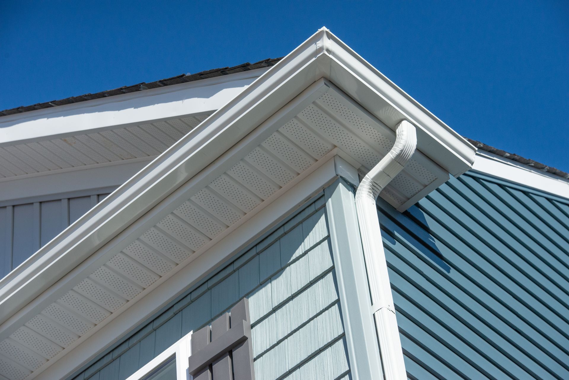 A house with a white gutter on the side of it