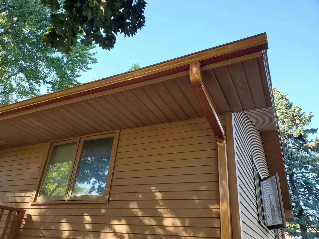 A house with a gutter on the side of it and a window.