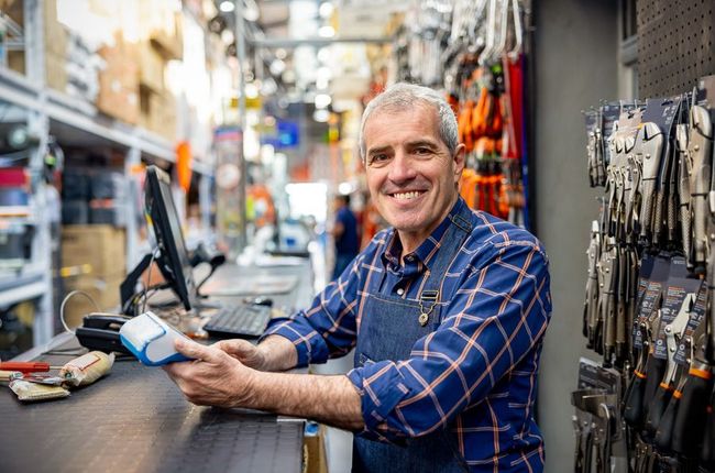 Business owner works at a customer service desk reviewing receipts.