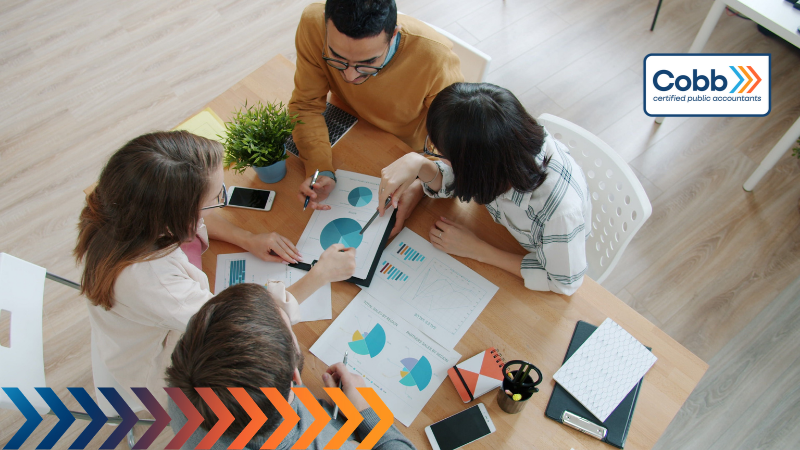 business owner and employees analyzing financial metrics