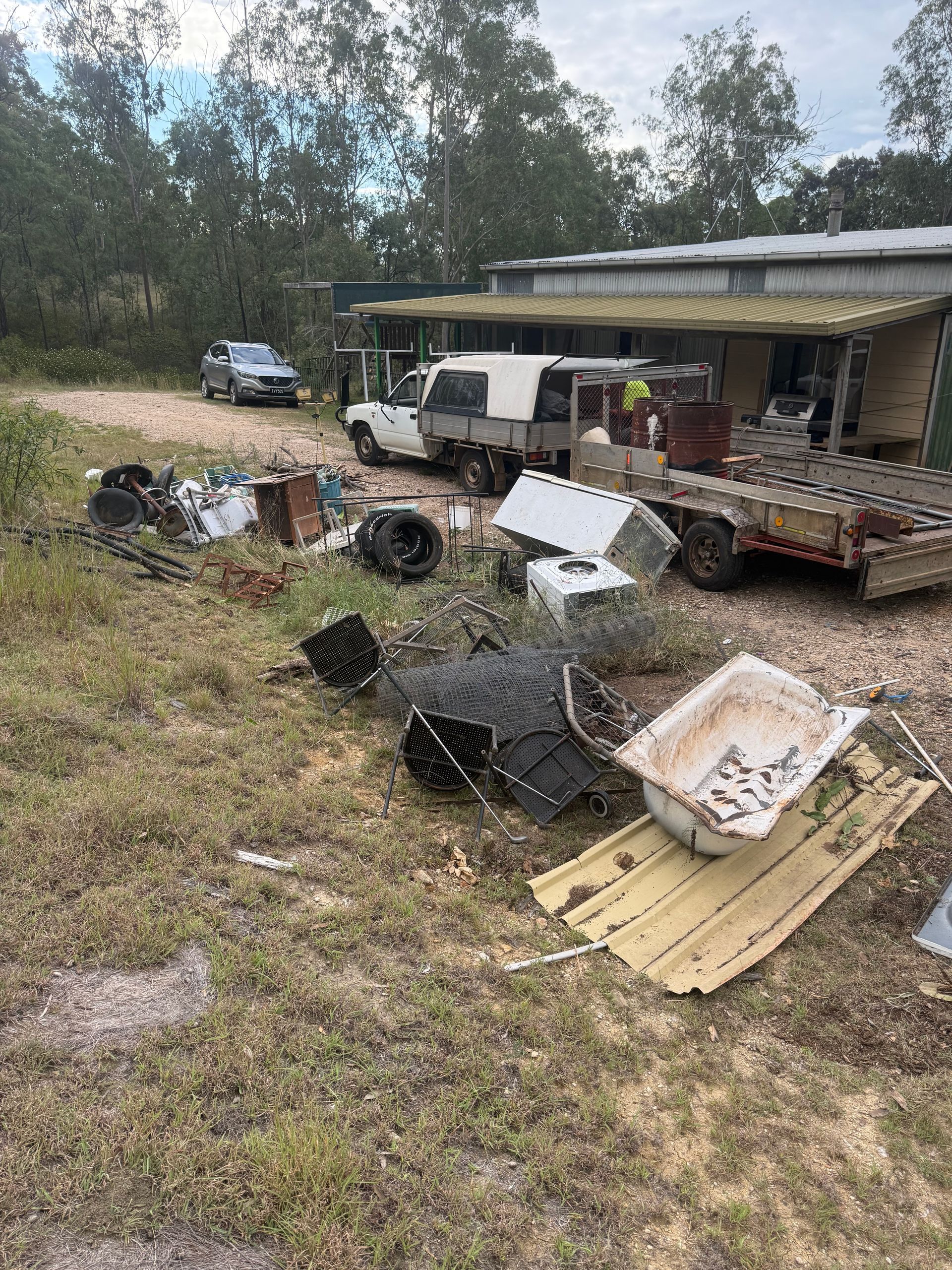 A pile of  discarded household items and rubbish including tyres and bathtub in Toowoomba
