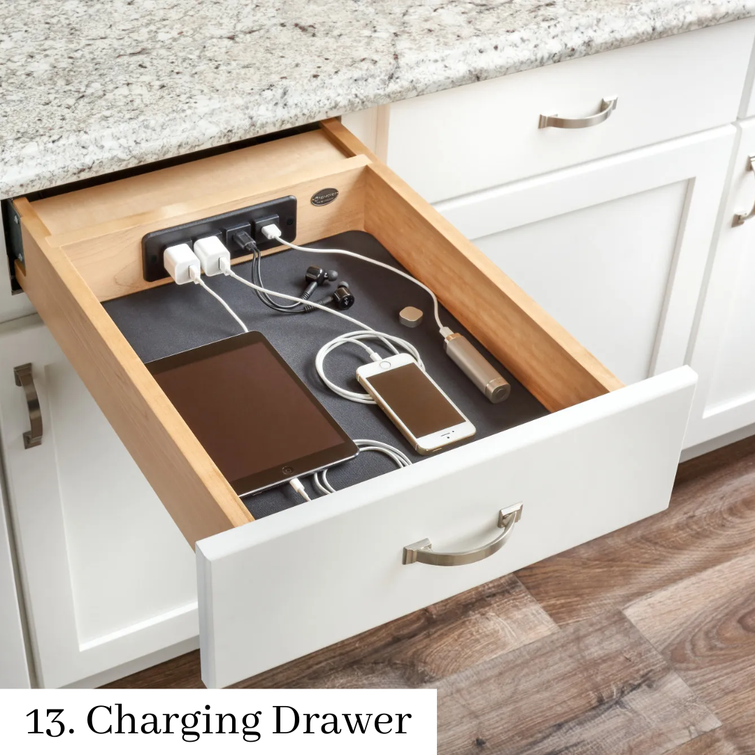 Open charging drawer with power strip and connected phones, tablets, and cables in a white cabinet