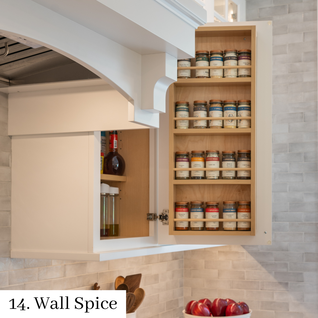Open wall spice cabinet filled with jars in a bright white kitchen