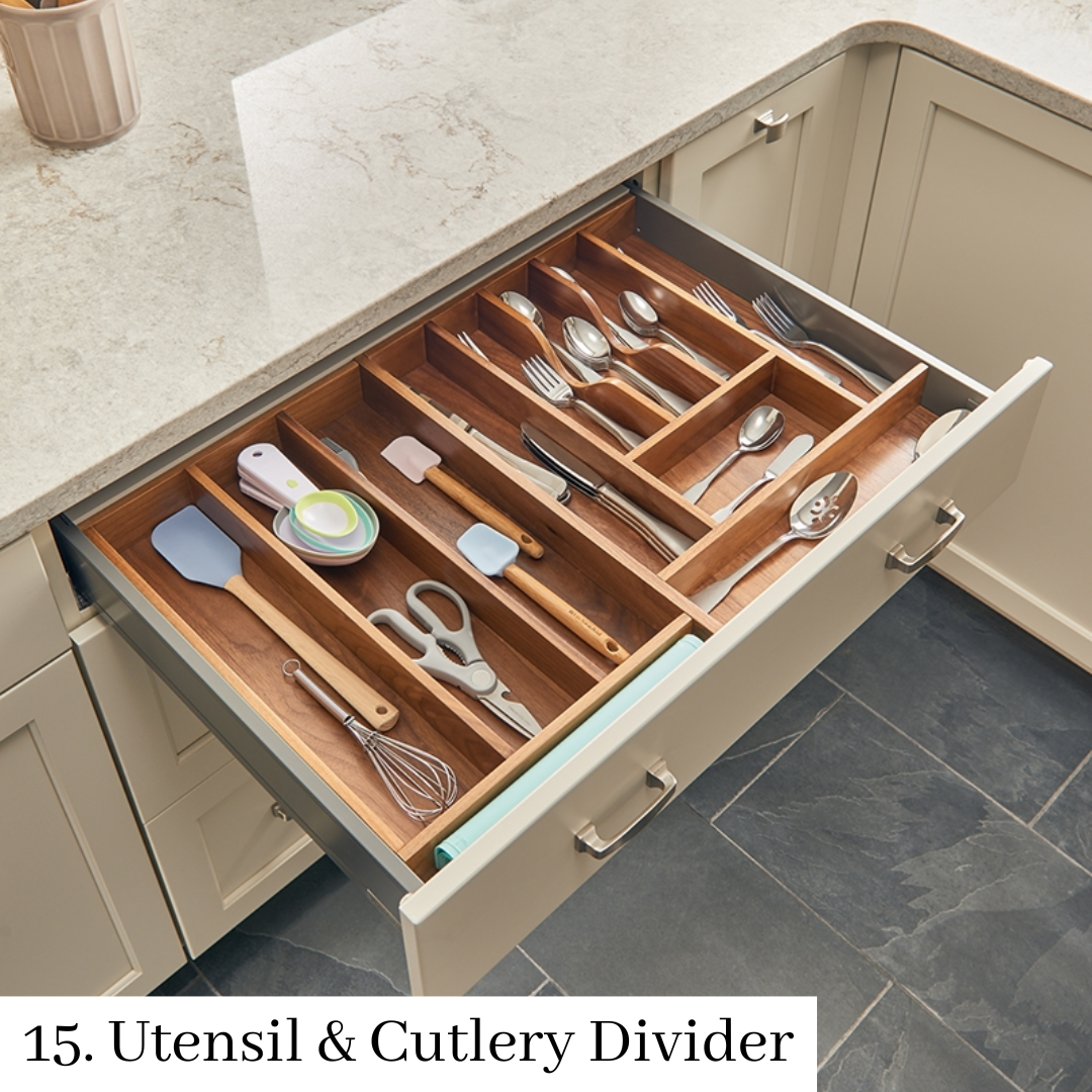 Open kitchen drawer with wooden utensil and cutlery dividers, holding silverware and cooking tools