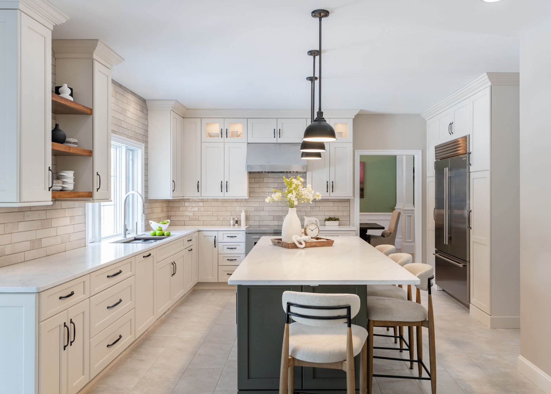 Bright modern kitchen with white cabinets, marble island, pendant lights, and stainless steel appliances
