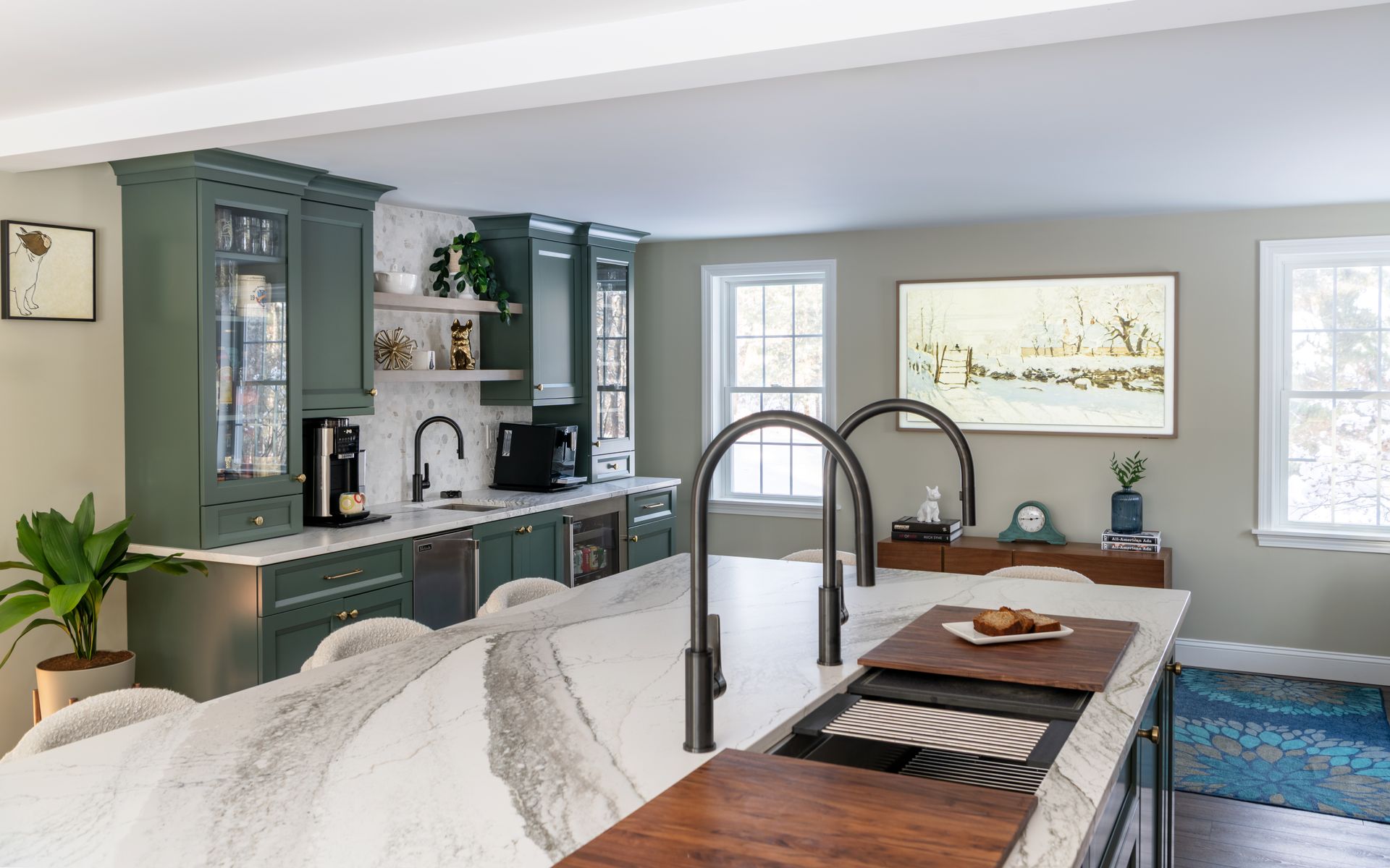 Bright, modern kitchen with blue cabinets, an island, and white bedding in the foreground