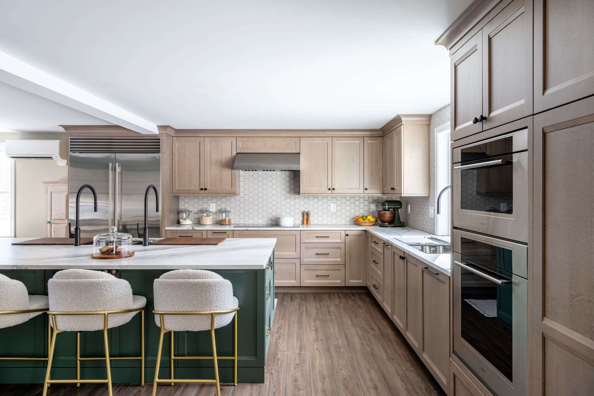 Bright modern kitchen with white cabinets, wood accents, and a green island with three stools