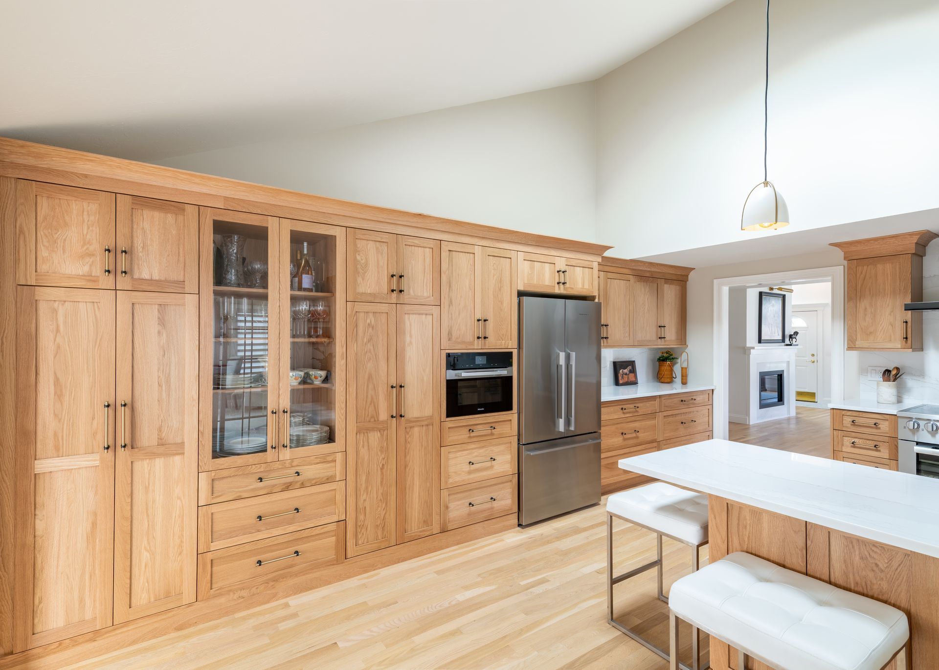 Bright modern kitchen with light wood cabinets, stainless appliances, and a white dining table