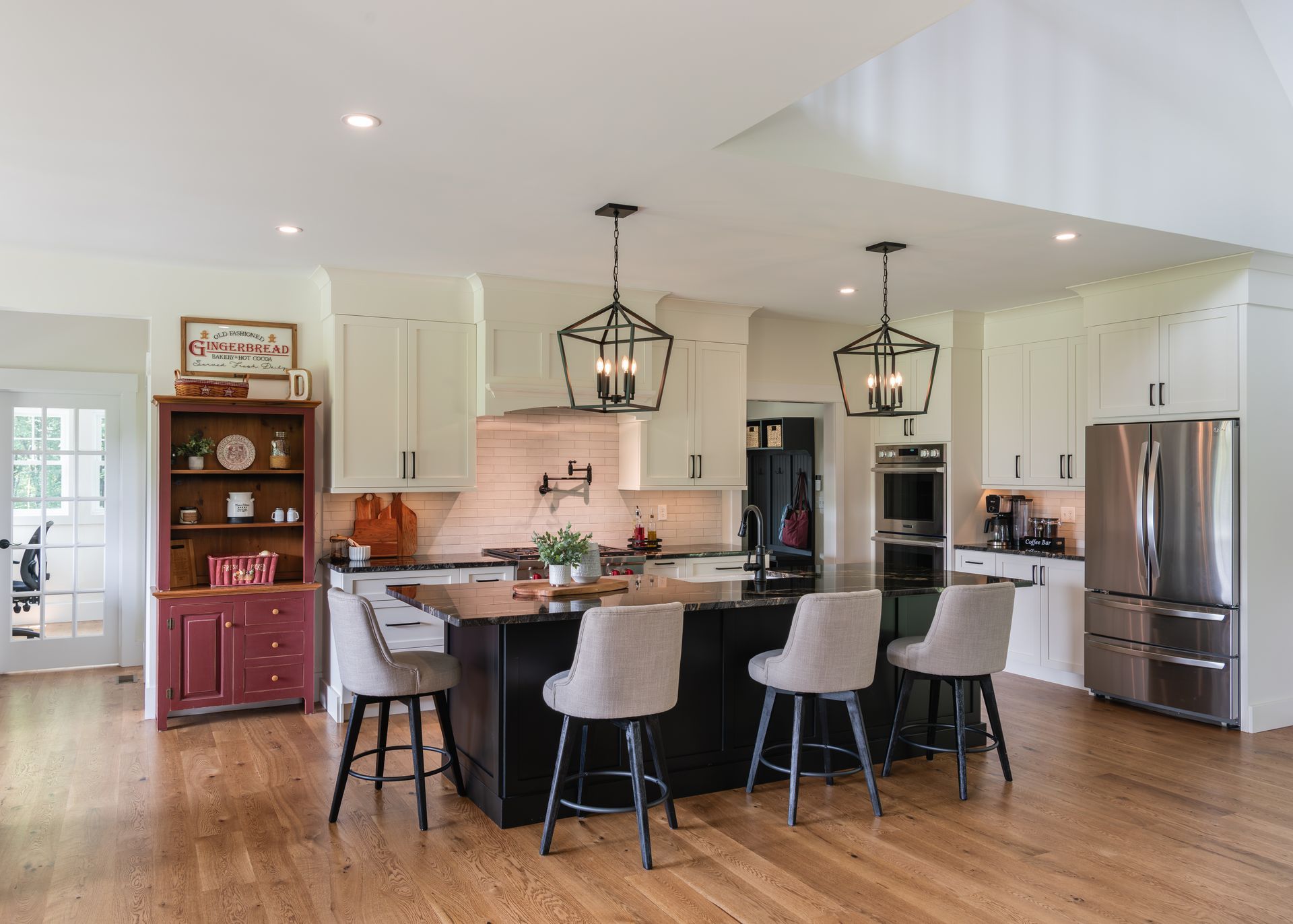 Bright modern kitchen with white cabinets, a large island, pendant lights, and stainless steel appliances