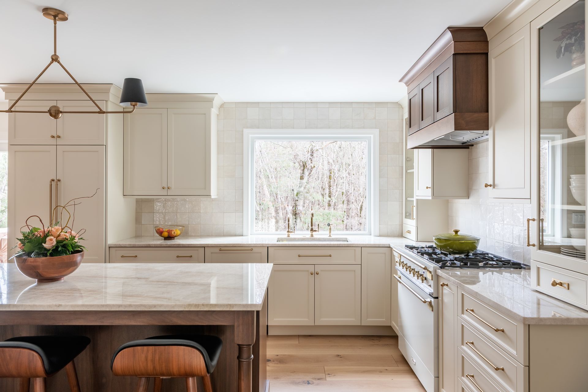 Bright modern kitchen with white cabinets, wood island, and large window over the sink