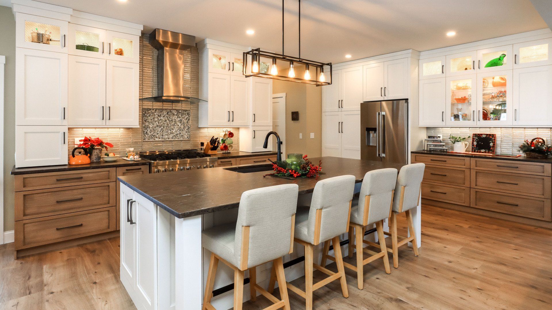 Bright modern kitchen with island, four stools, stainless appliances, and wood floors
