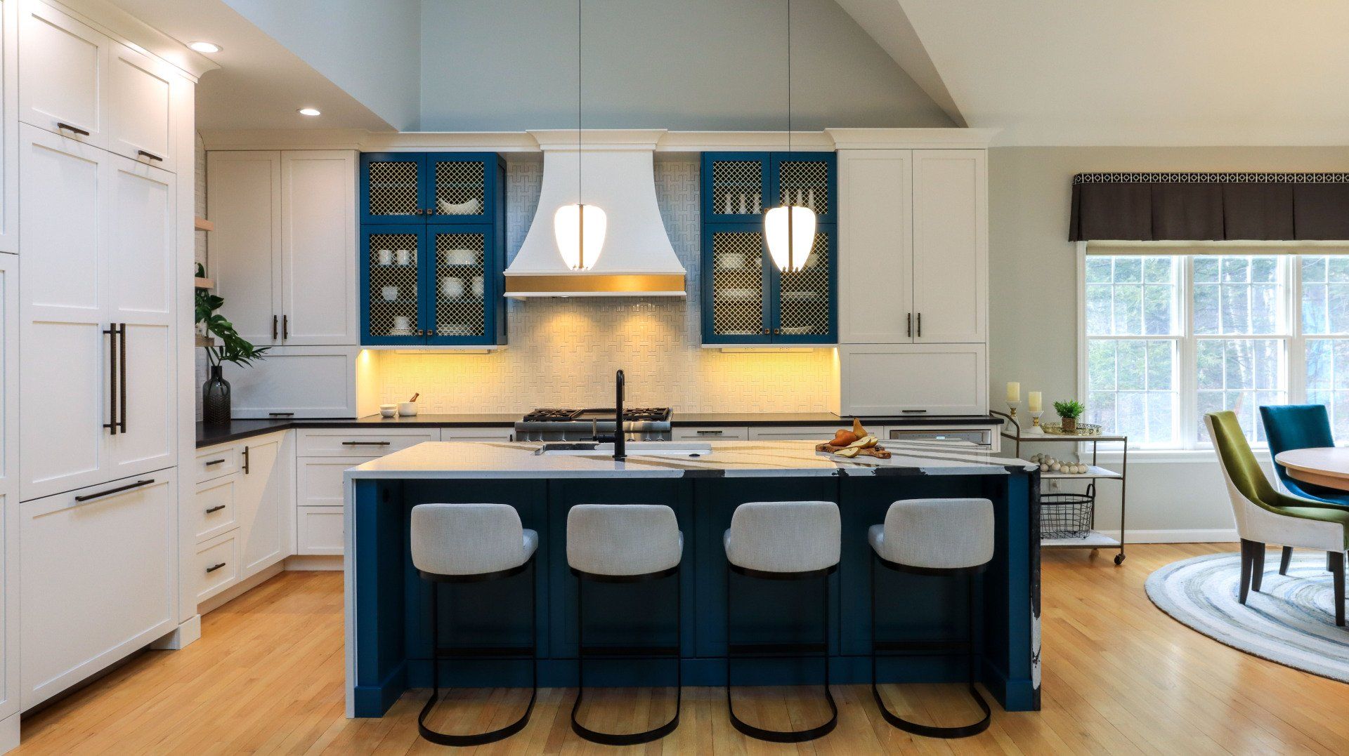 Modern kitchen with blue island, four stools, white cabinets, and pendant lights
