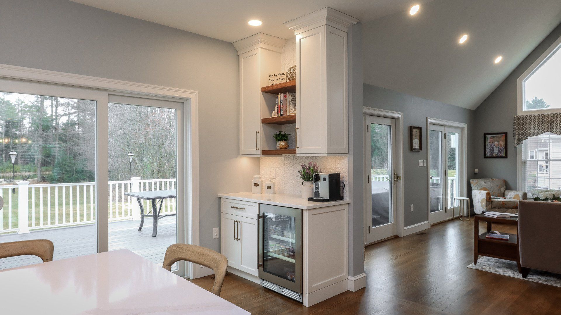 Open-concept kitchen and dining area with sliding doors to a deck and large windows.