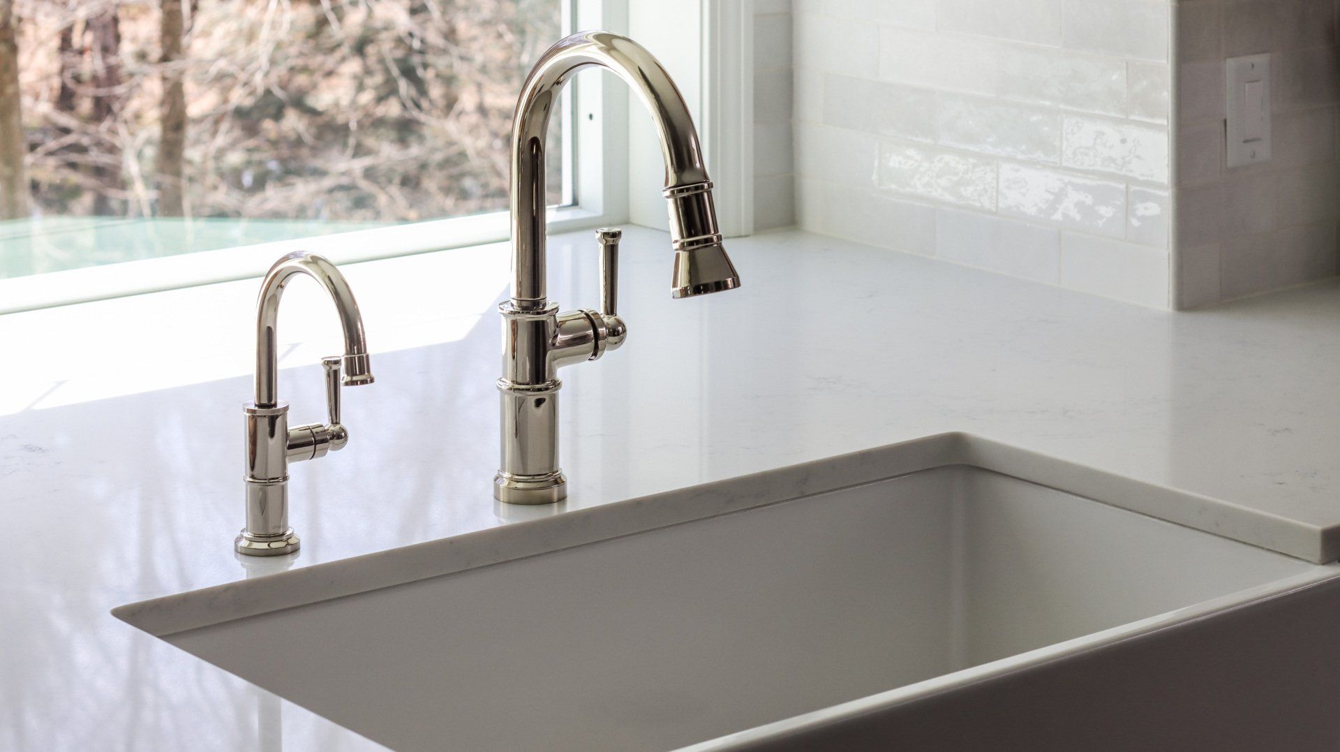 Modern kitchen sink with chrome faucet and bright tiled backsplash