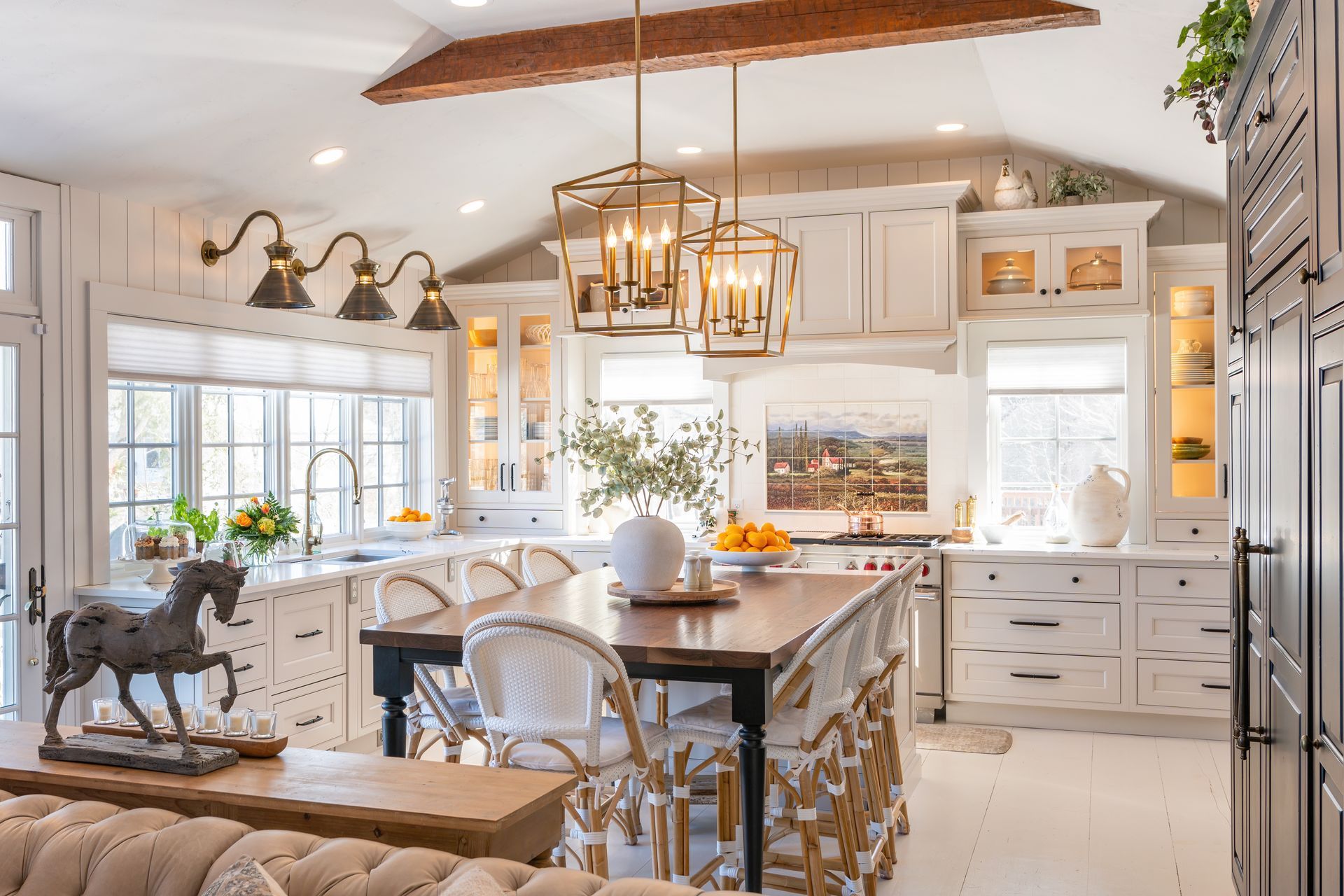 Bright, airy kitchen with white cabinets, island seating, and warm pendant lights