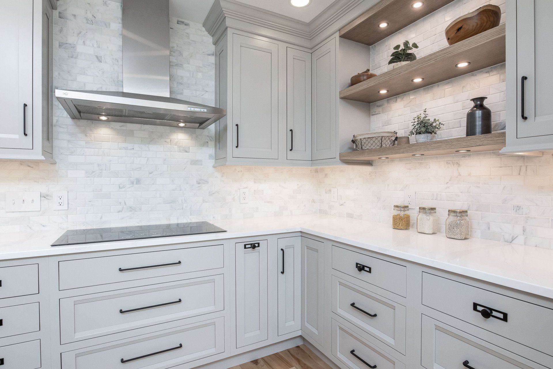 Bright white modern kitchen with marble backsplash, gray cabinets, and open shelving