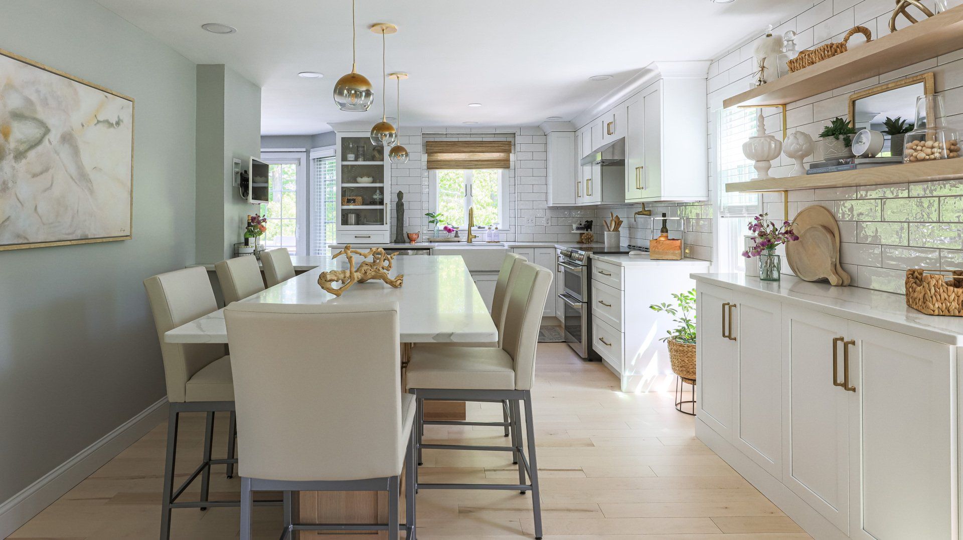 Bright modern dining room and kitchen with white decor, long table, and built-in cabinets