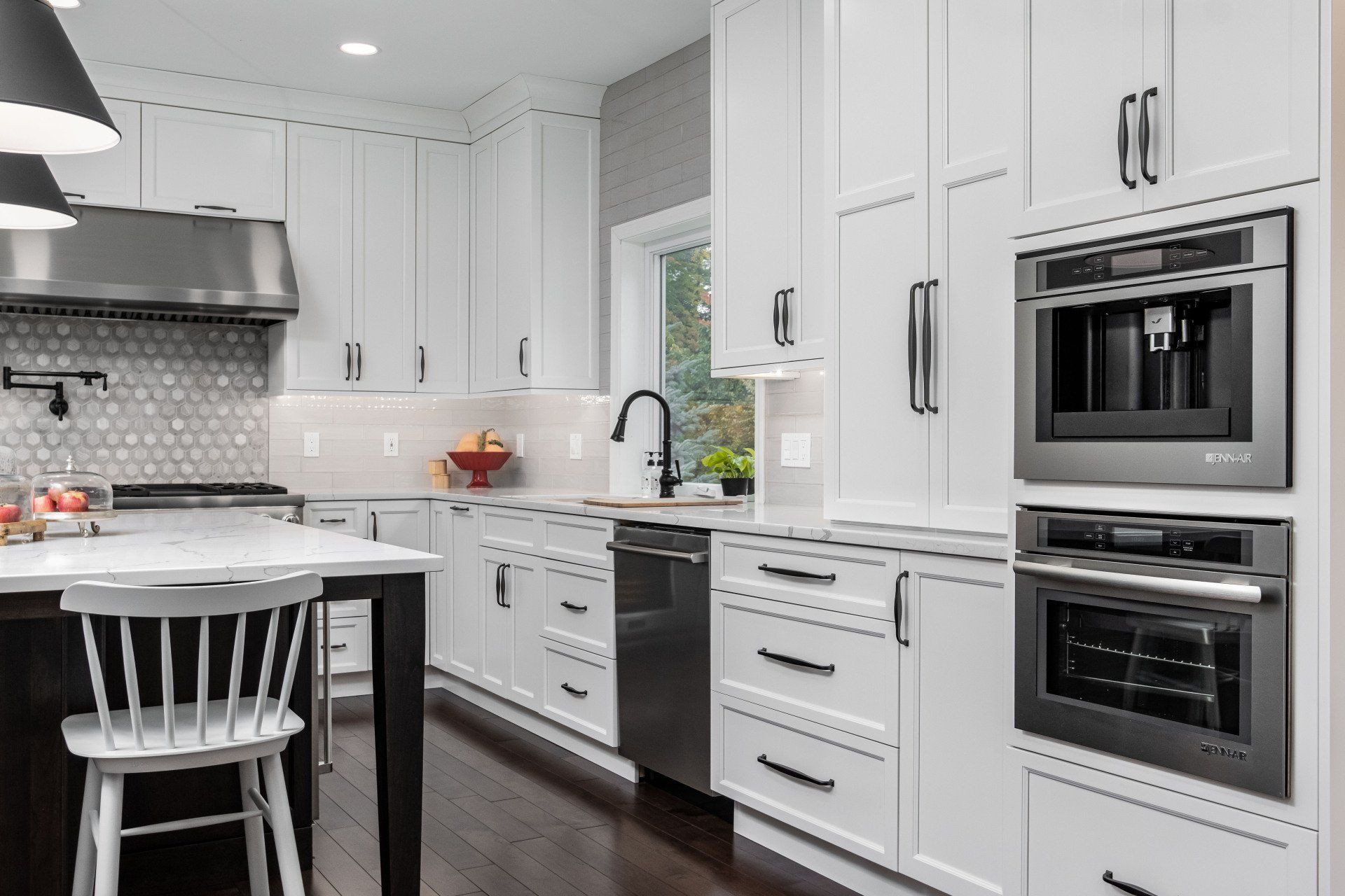 Bright white modern kitchen with stainless steel appliances, island, and dark wood floor