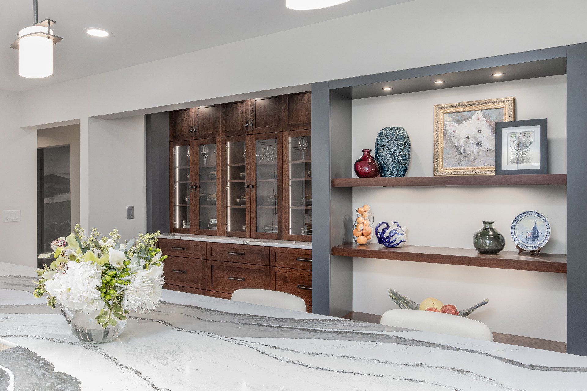 Modern living room with built-in wooden shelves and decorative vases on display, seen from a white sofa