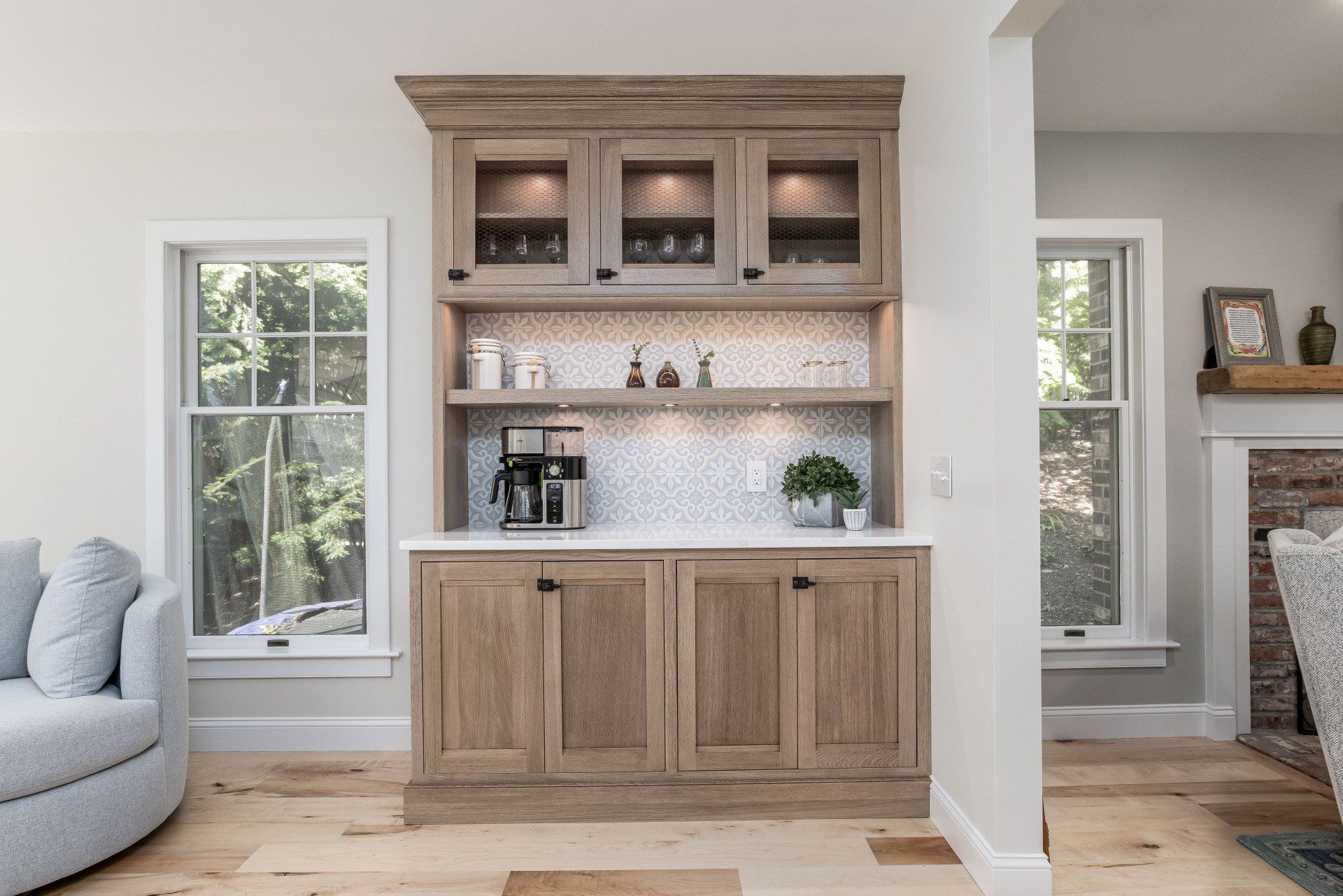 Built-in wooden hutch in a bright living room with windows and a fireplace nearby