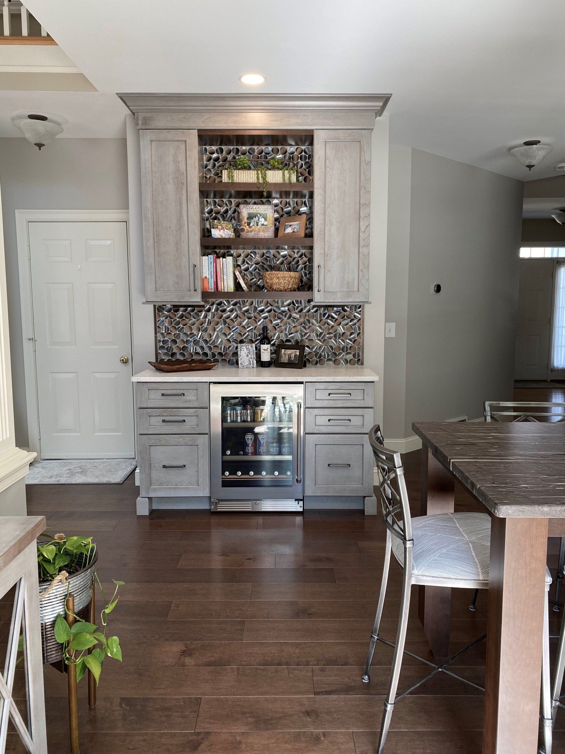 Kitchen with white cabinets, mosaic tile backsplash, wine fridge, and dark hardwood floors