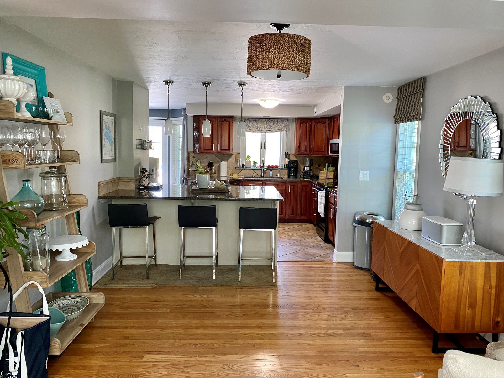 Bright open kitchen with island, wood cabinets, and hardwood floors, seen from a dining area