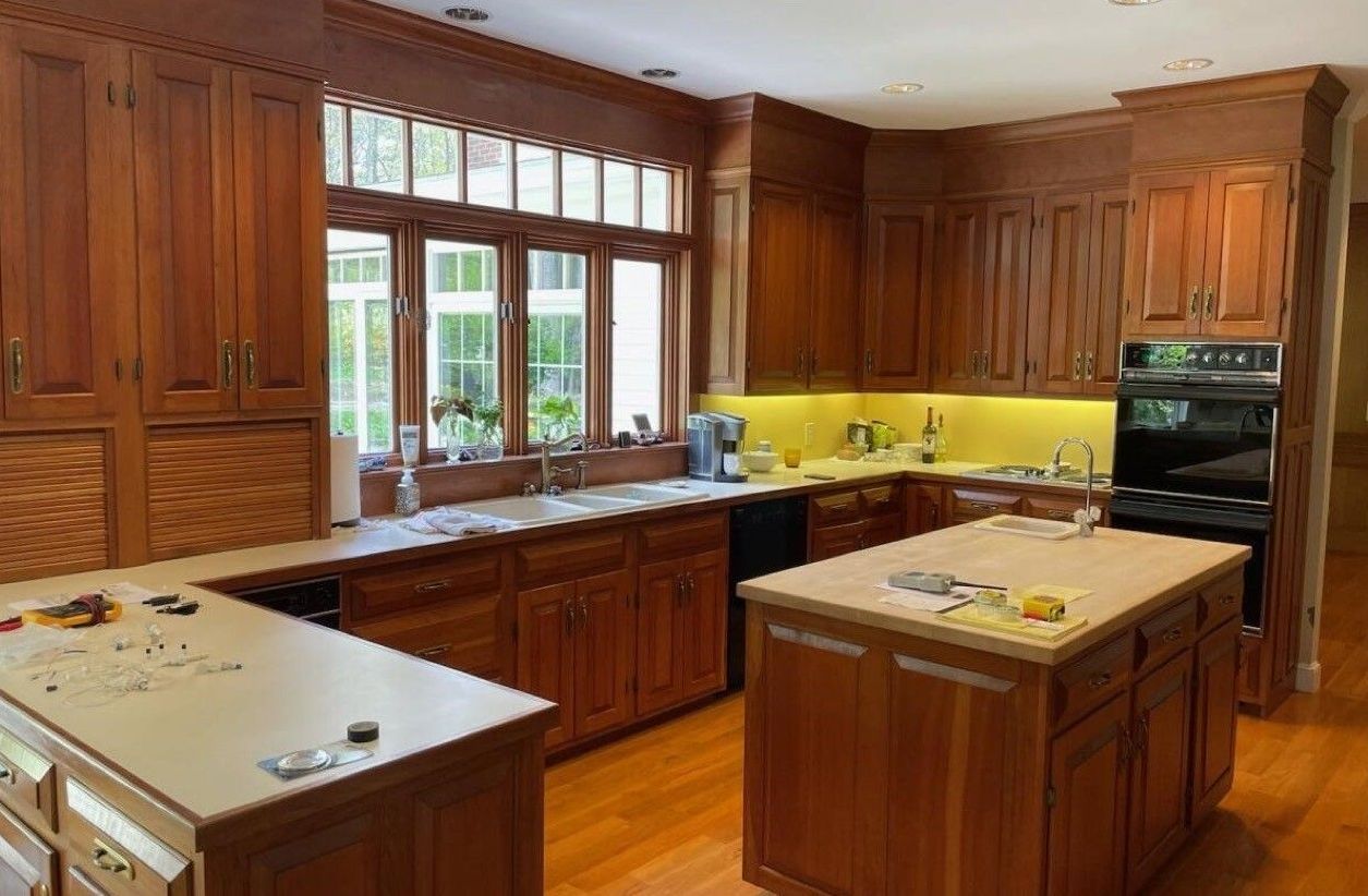 Spacious kitchen with wooden cabinets, two islands, yellow backsplash, and large window over the sink
