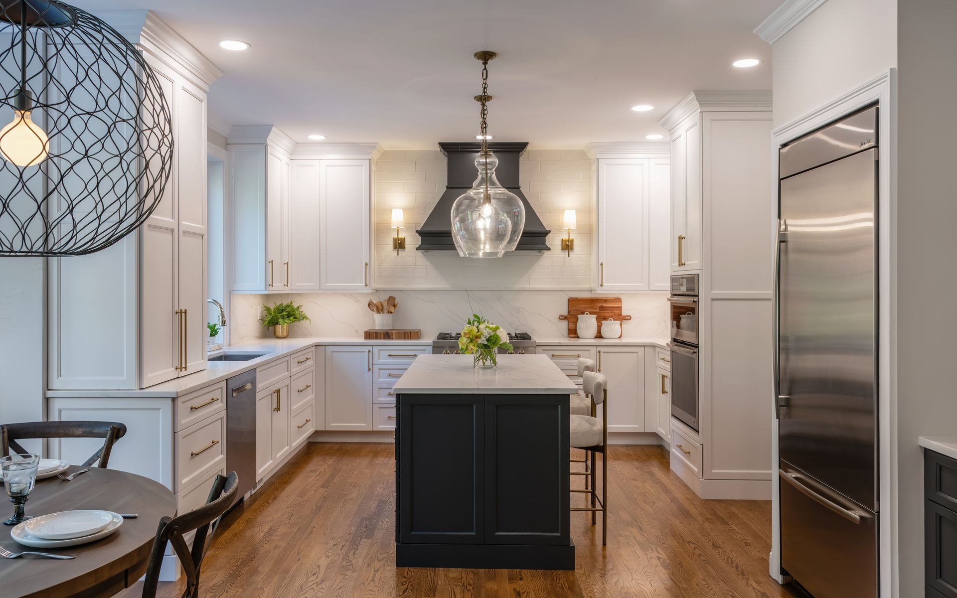 Modern white kitchen with island, stainless steel refrigerator, and pendant lighting