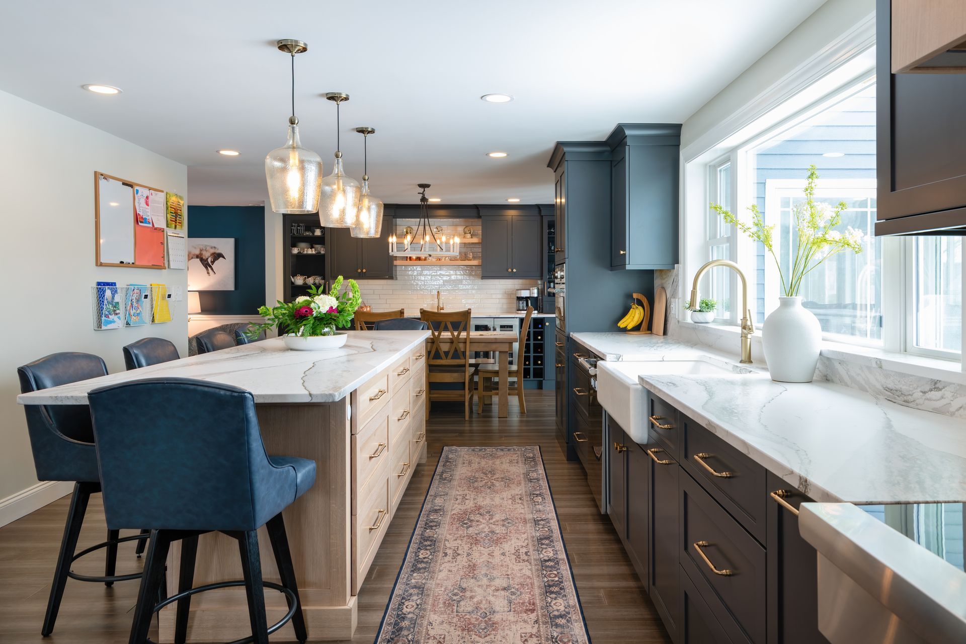 Bright modern kitchen with large island, pendant lights, and sunlit window sink