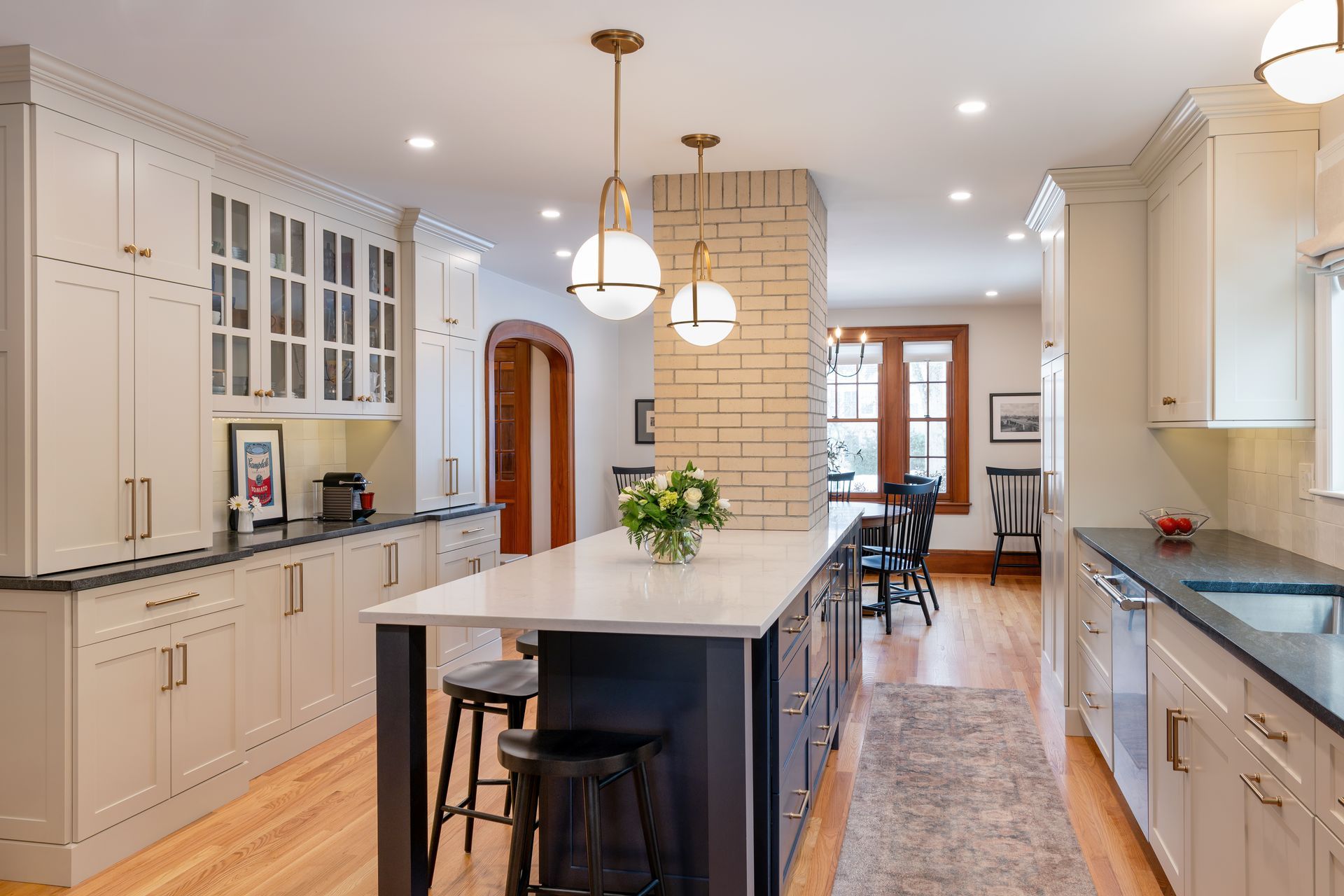 Bright modern kitchen with white cabinets, large island, pendant lights, and a long runner rug