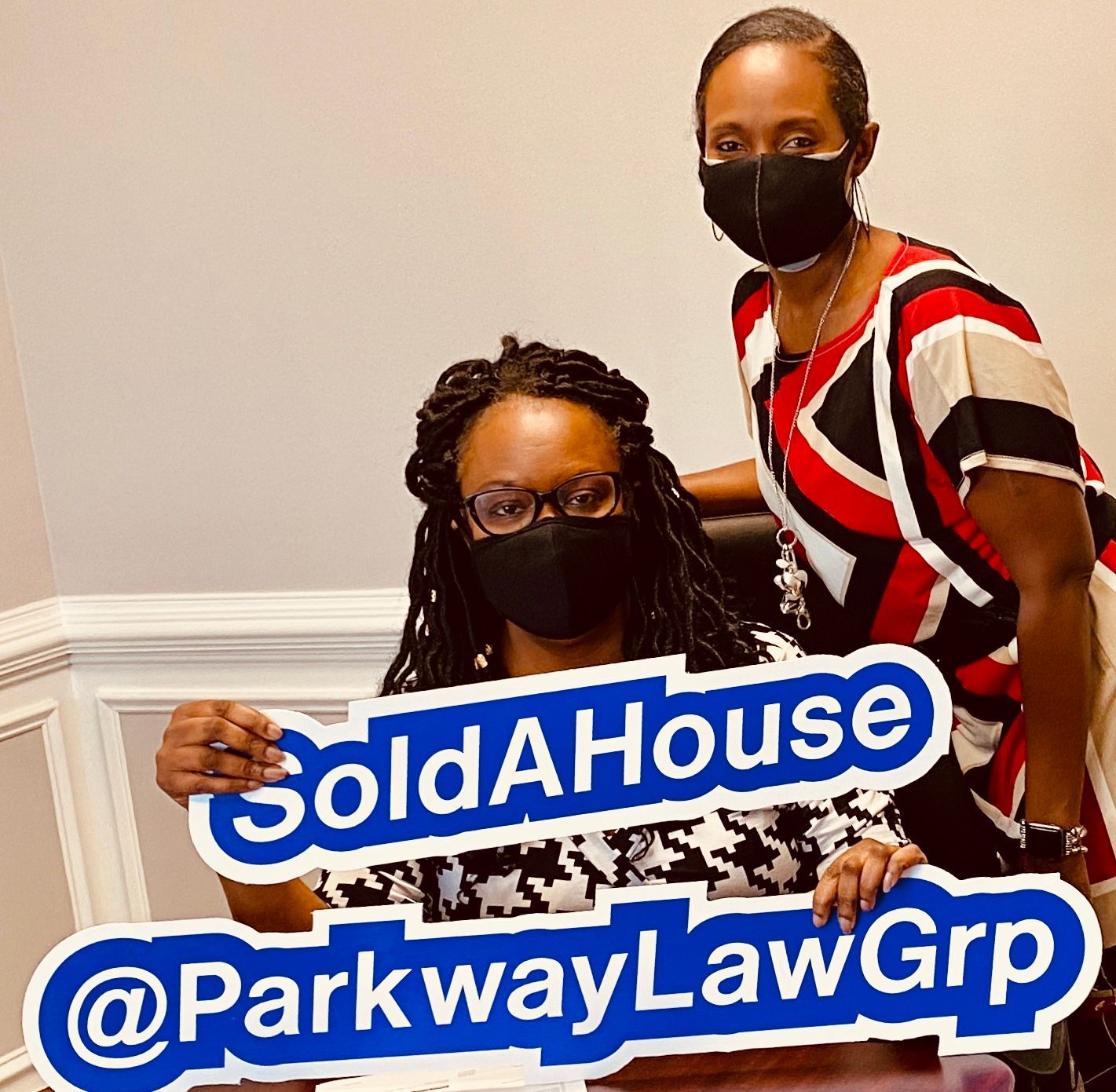 Two masked women holding a