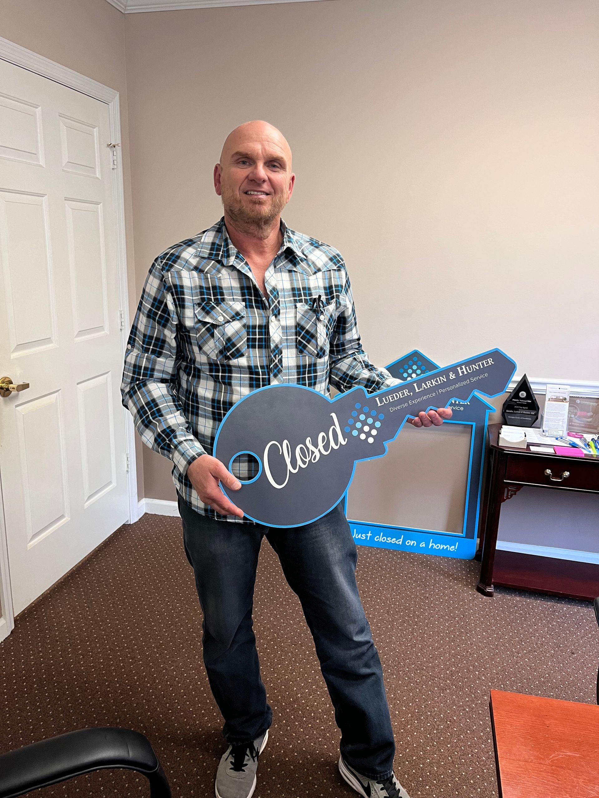 Rhonda Martin, Georgia Realtor clients holding a large key-shaped sign that reads