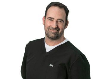 A man with a beard wearing a black scrub top