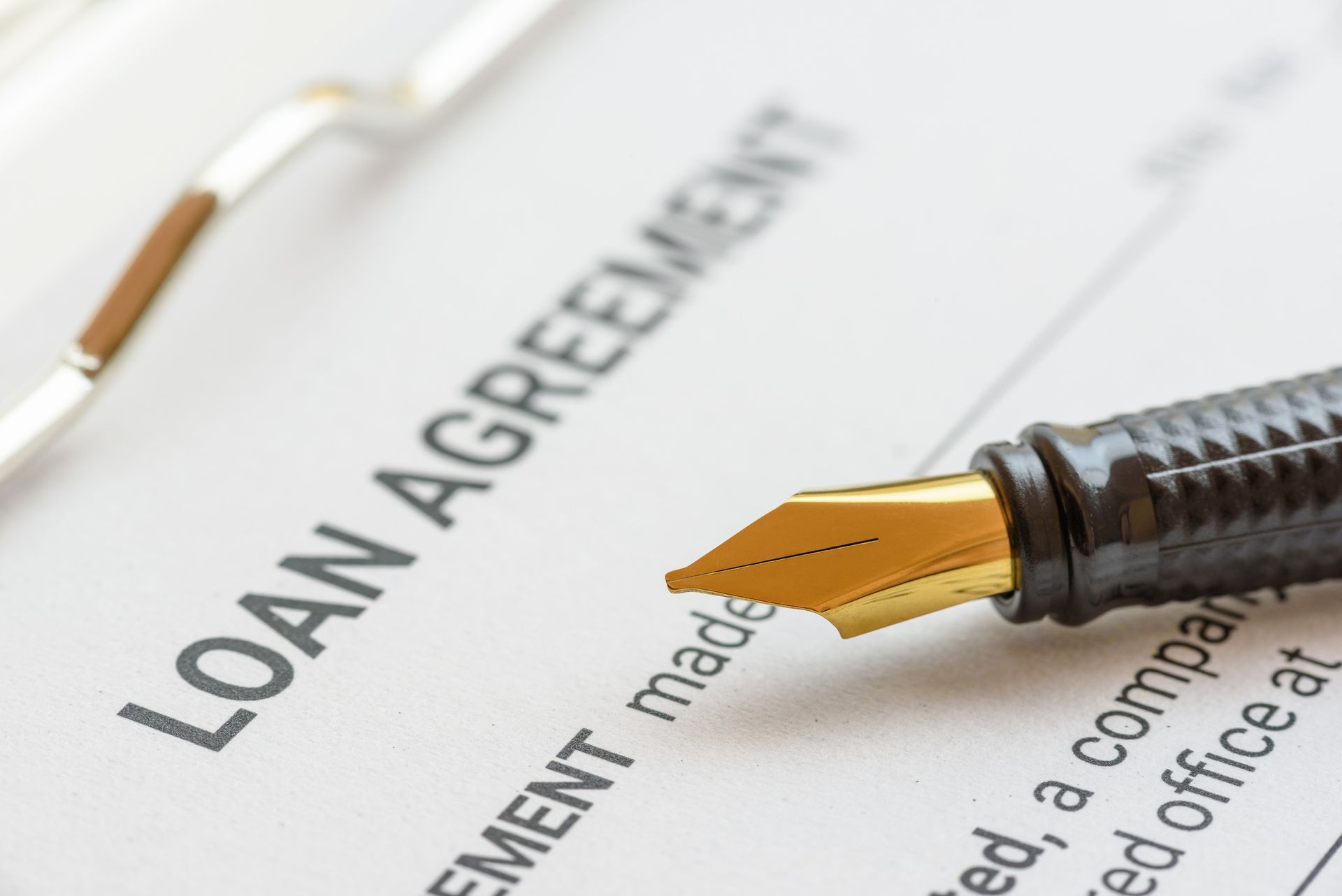 A fountain pen is sitting on top of a loan agreement