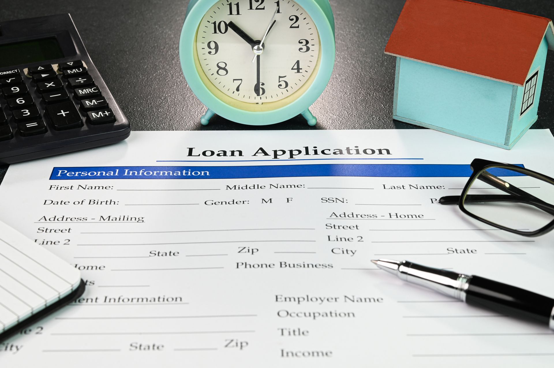 A loan application form with a clock and a pen