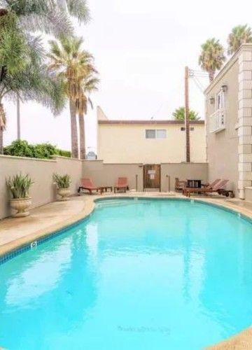 A large swimming pool with palm trees at the back. Sky Properties Inc. - Premier Property Management Company in Toluca Lake