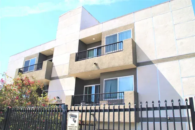 photo showing a fenced apartment building exterior at Fulton Avenue