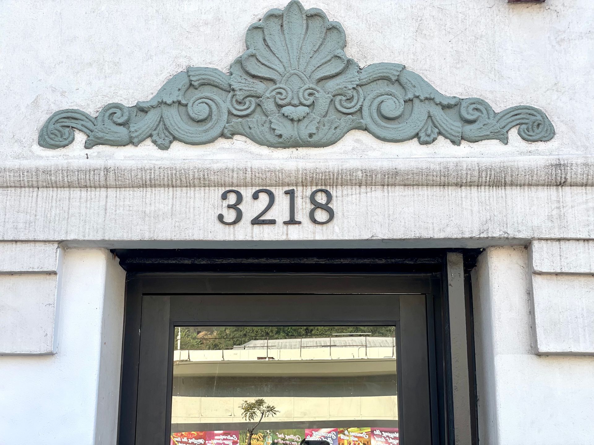 photo of the Ansley facade showing a close-up view of the building address and a floral design accent above it
