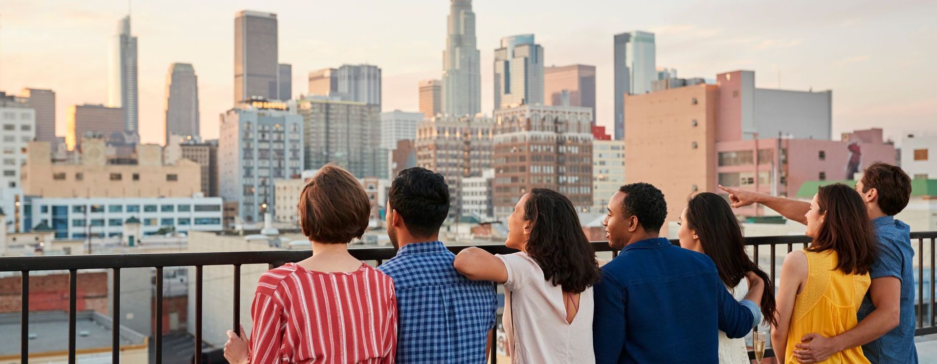 Group of people on a balcony looking at the city skyline. 