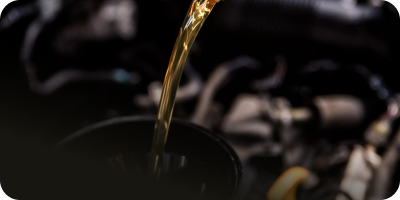 A close up of a person pouring oil into a cup | Oceanside Tire and Service Center Tire Pros