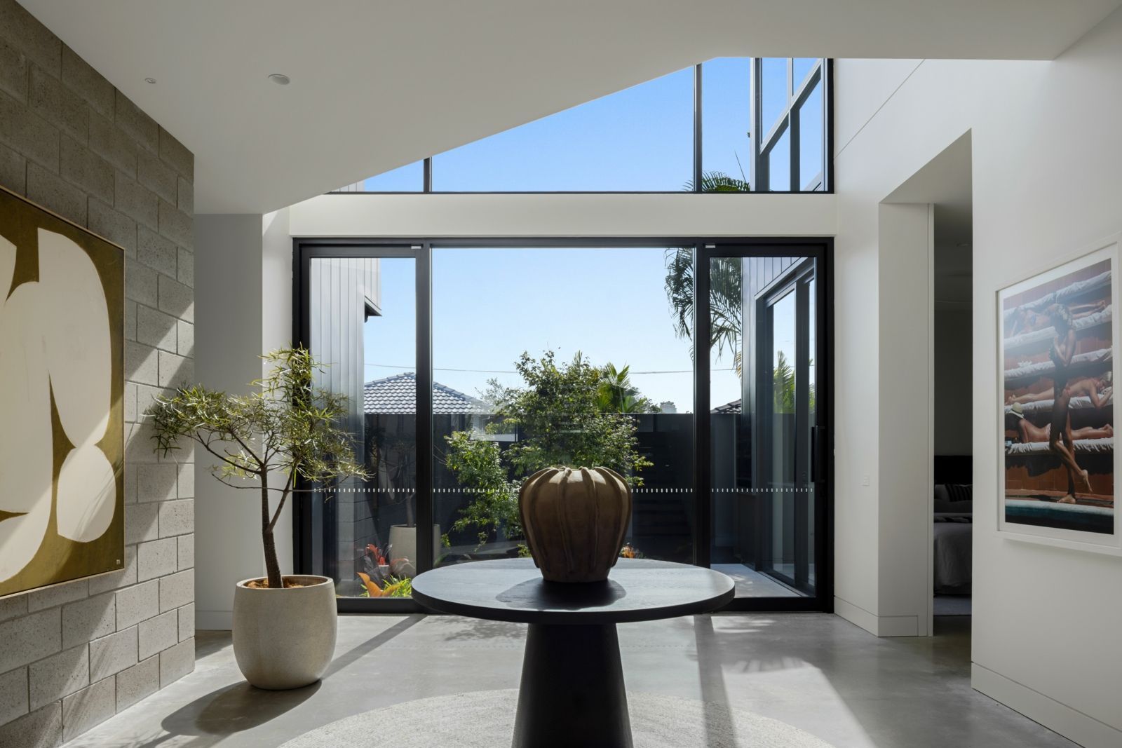 Two-story white house with a pool, sunbeds, and Building Design Queensland award text.