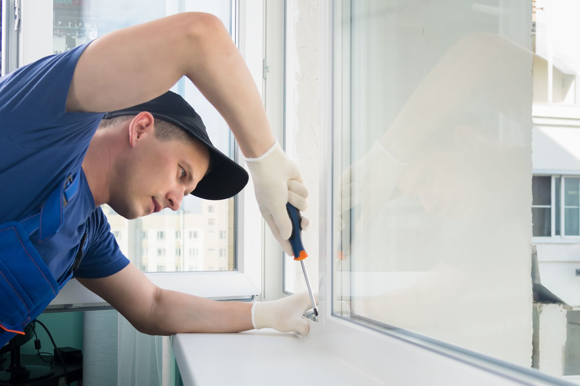 A technician installing a window in an office setting. A technician installing a window in an office setting.