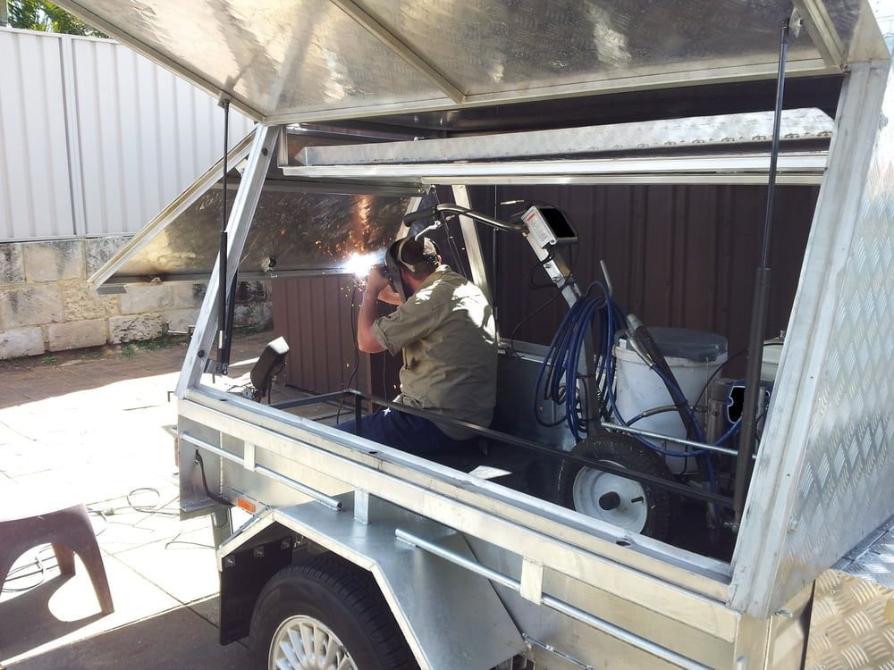 A Man Is Welding in The Back of A Trailer — Ballarat Trailer Hire in Alfredton, VIC