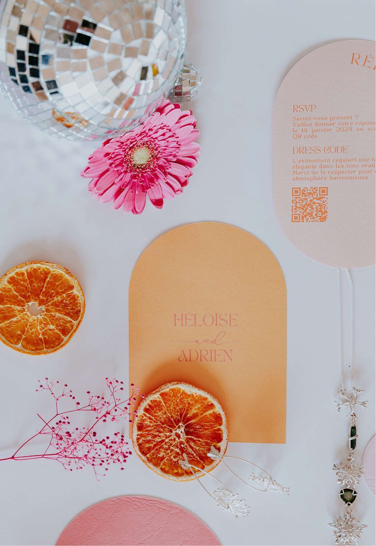 Une boule disco, des fleurs, des oranges et un menu sont sur une table.
