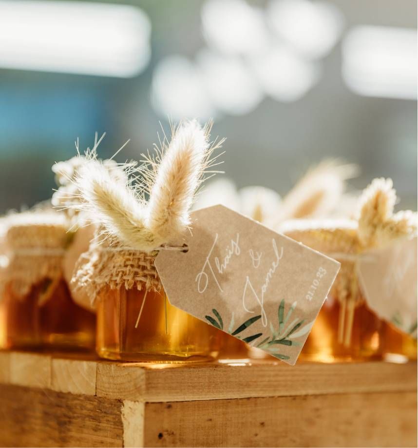 Une boîte en bois remplie de pots de miel avec une étiquette attachée dessus