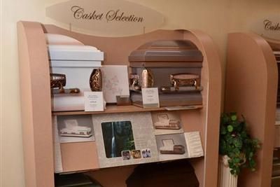 Curved beige display shelves with books and magazines in a café or waiting area